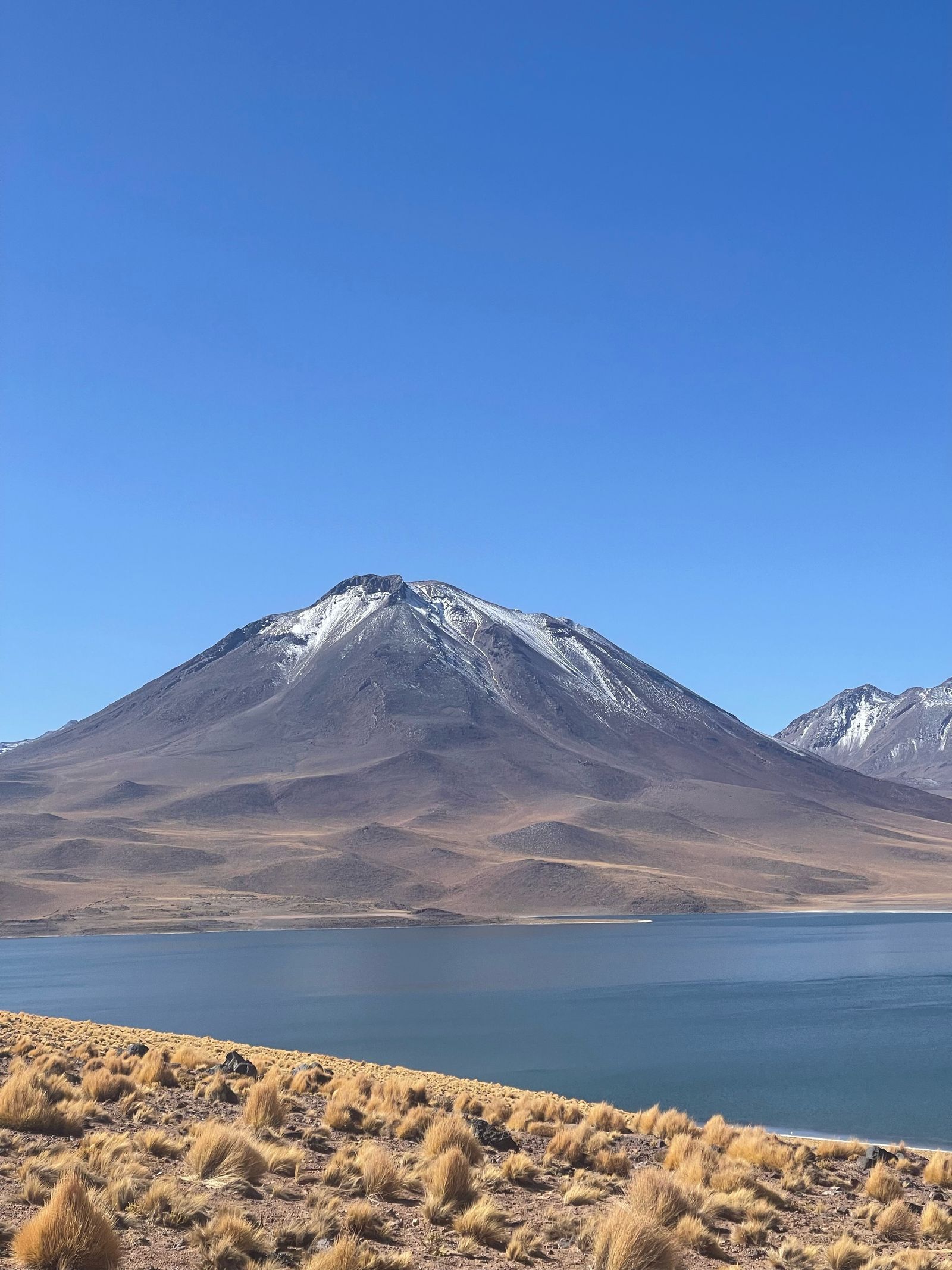 Volcán nevado y laguna en el desierto de Atacama, Chile