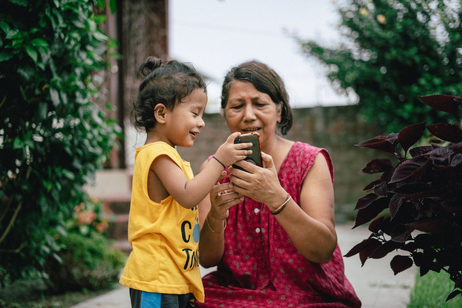 Niña mostrándole el teléfono a su mamá, uso familiar de internet