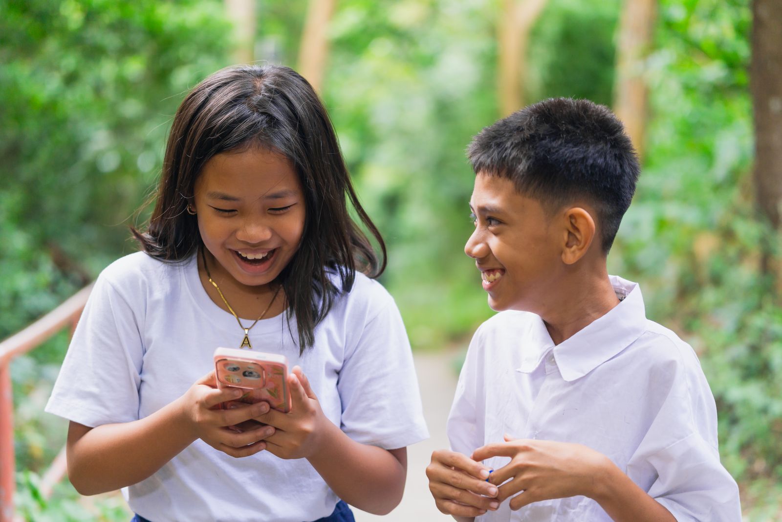 Niños revisando un celular al aire libre en familia
